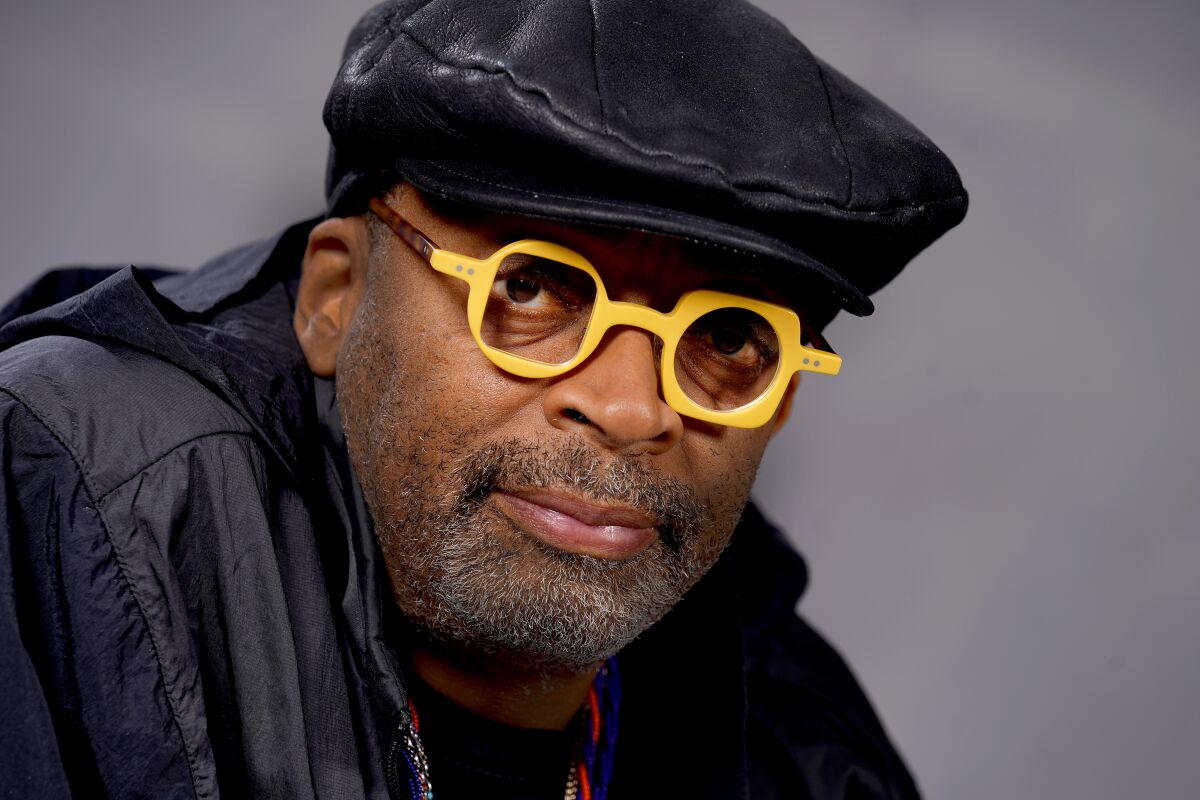 Spike Lee in a black hat and yellow glasses