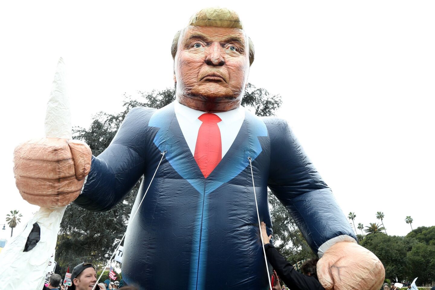 Manifestantes protestan con un muñeco inflable con la imagen de Trump. El mandatario aterrizó en la tarde en el Aeropuerto Internacional de Los Ángeles, donde ningún funcionario local acudió a darle la bienvenida.