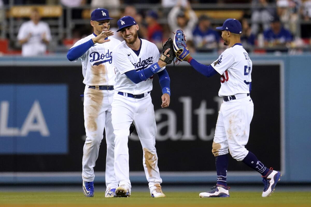 Cody Bellinger, center, celebrates with Dodgers teammates Trayce Thompson, left, and Mookie Betts.