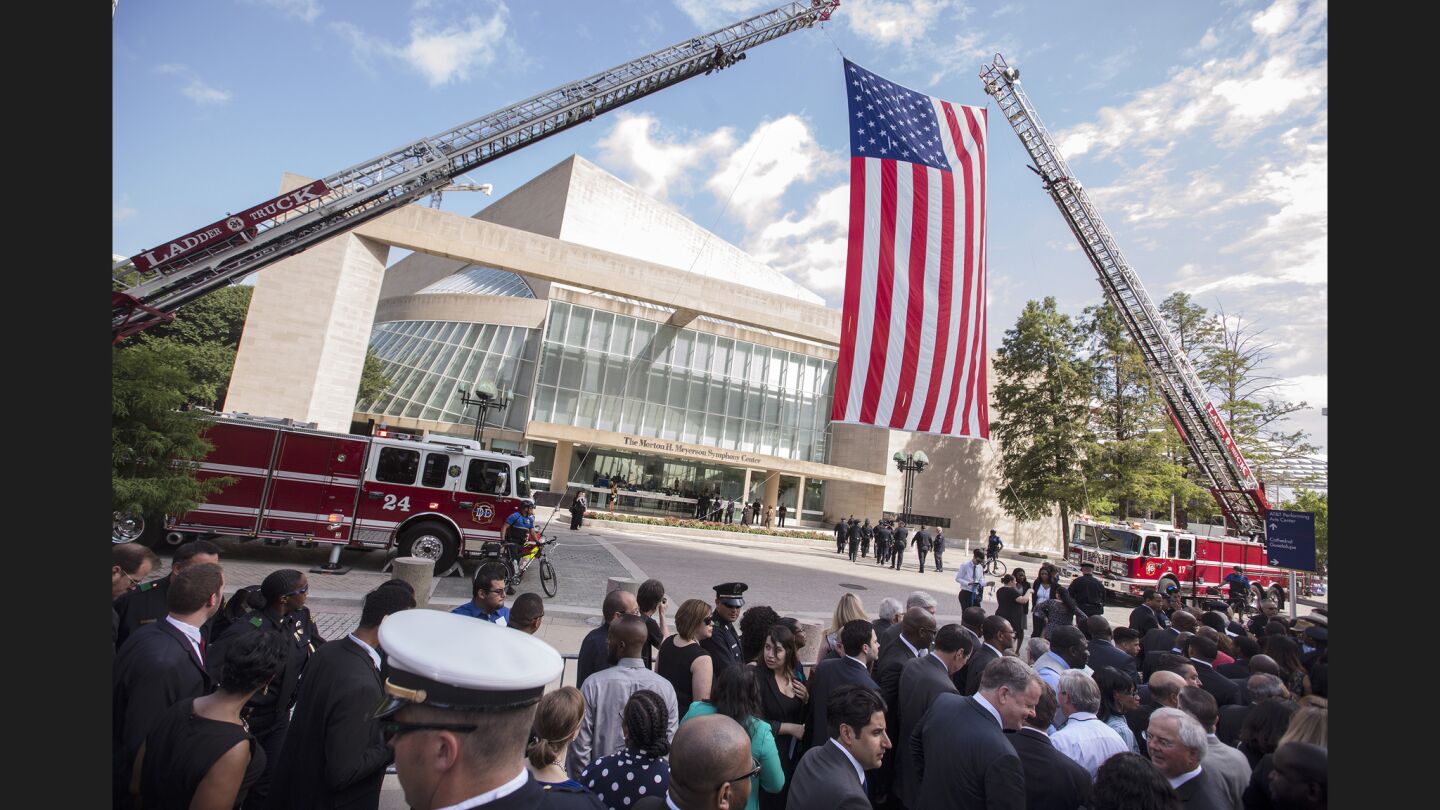 A crowd gathers before the memorial at the Morton H. Meyerson Symphony Center in Dallas, where President Obama and former President George W. Bush spoke.