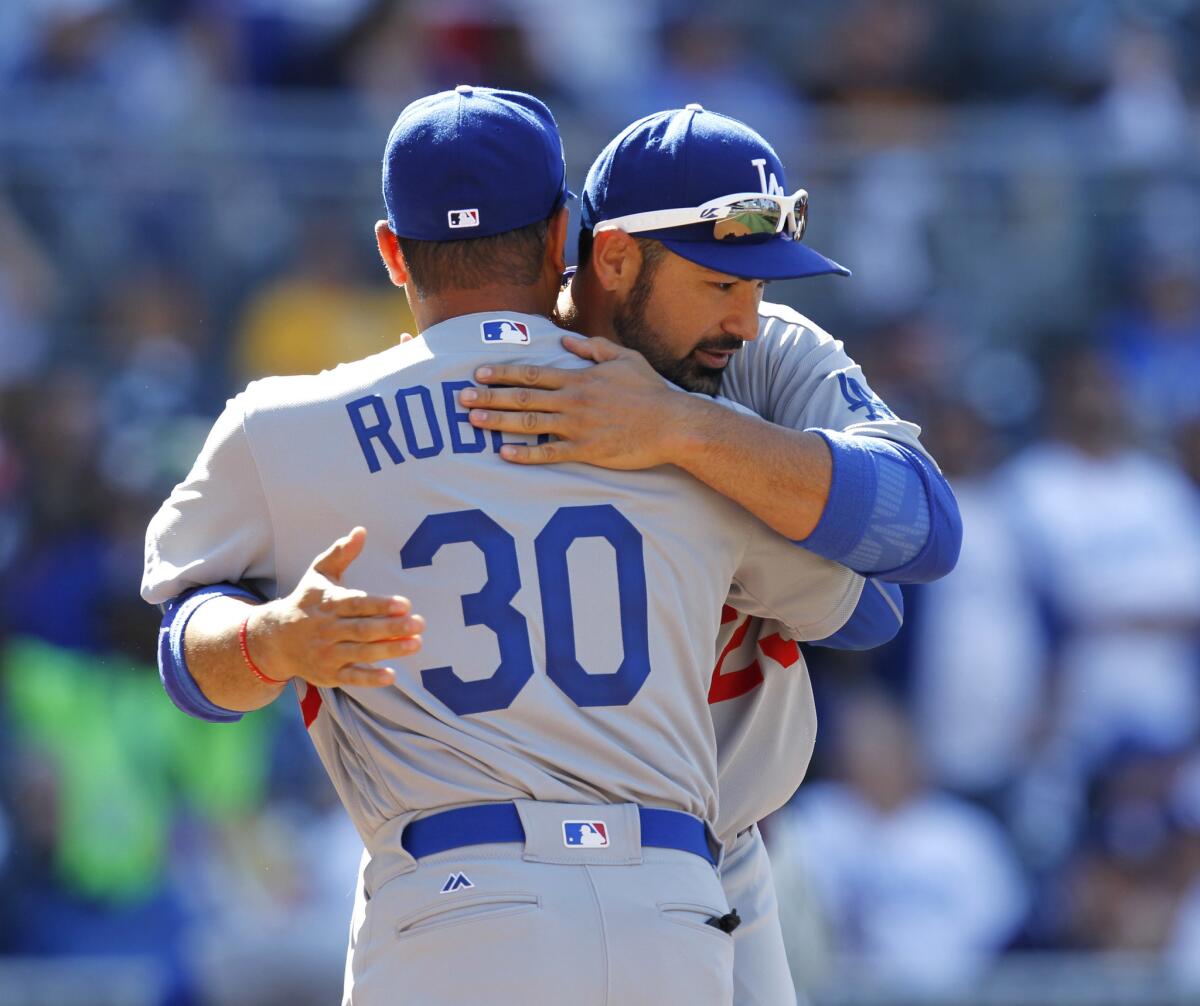 Dodgers first baseman Adrian Gonzalez hugs Manager Dave Roberts before an opening day game agaisnt the Padres at Petco Park.