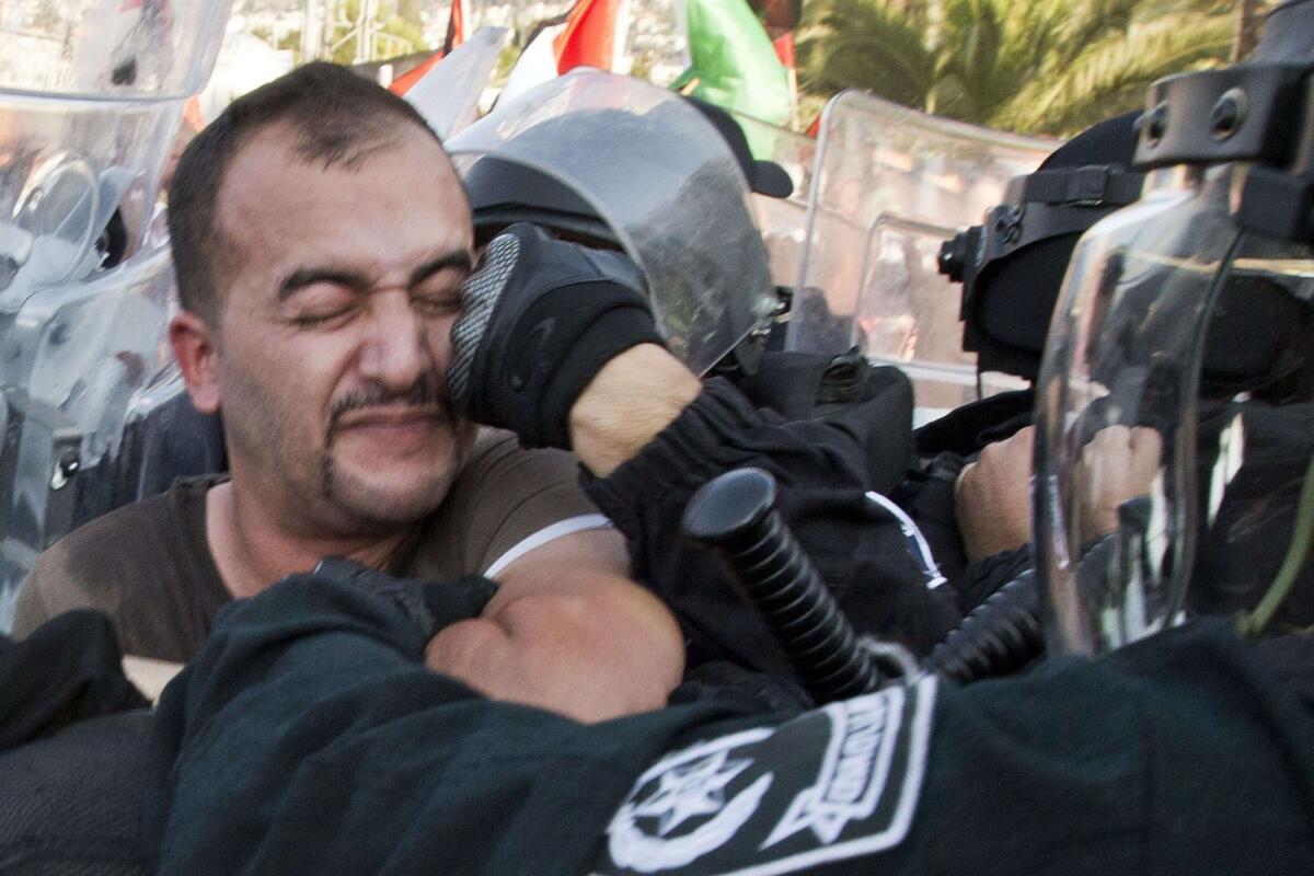 A protester is struck as he confronts Israeli police during a demonstration against government plans to resettle Bedouins.