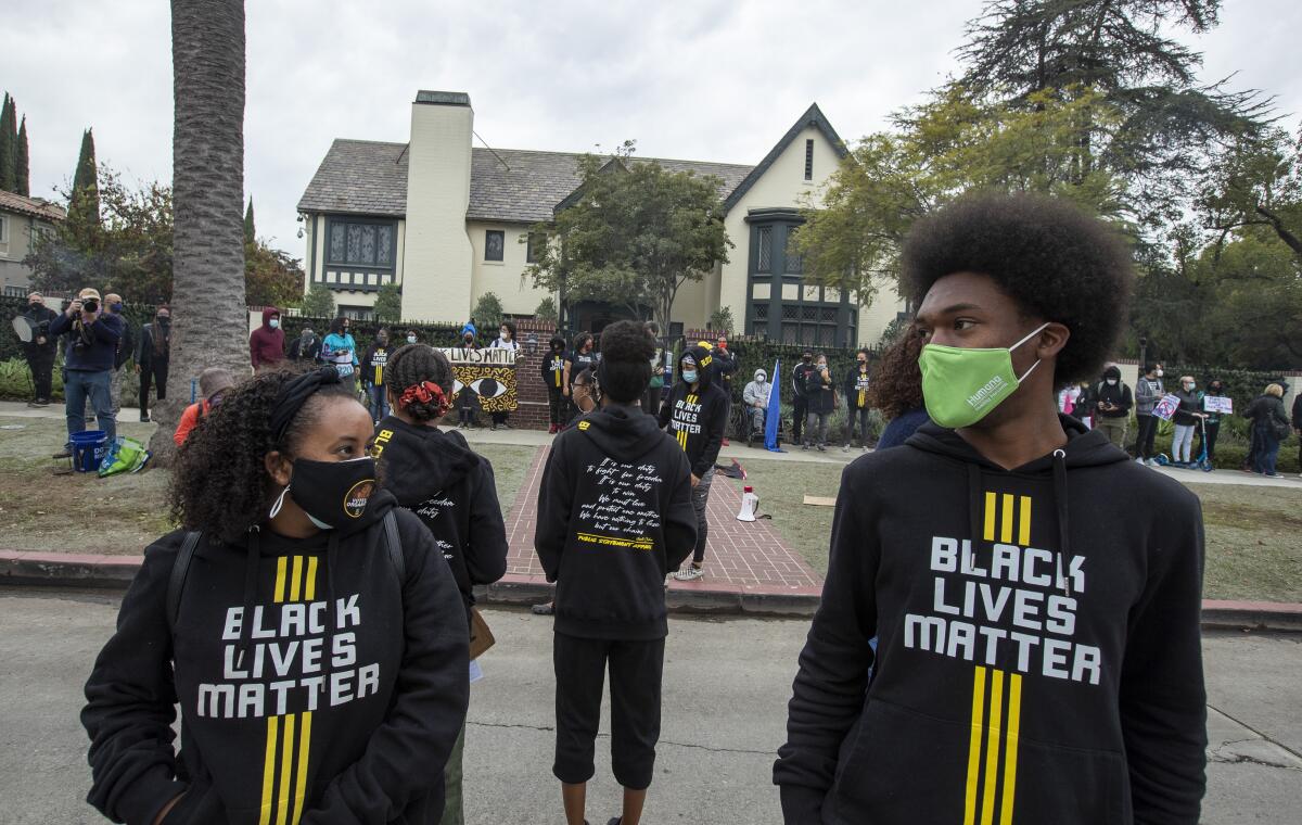 Demonstrators wearing Black Lives Matter sweatshirts stand outside Getty House 