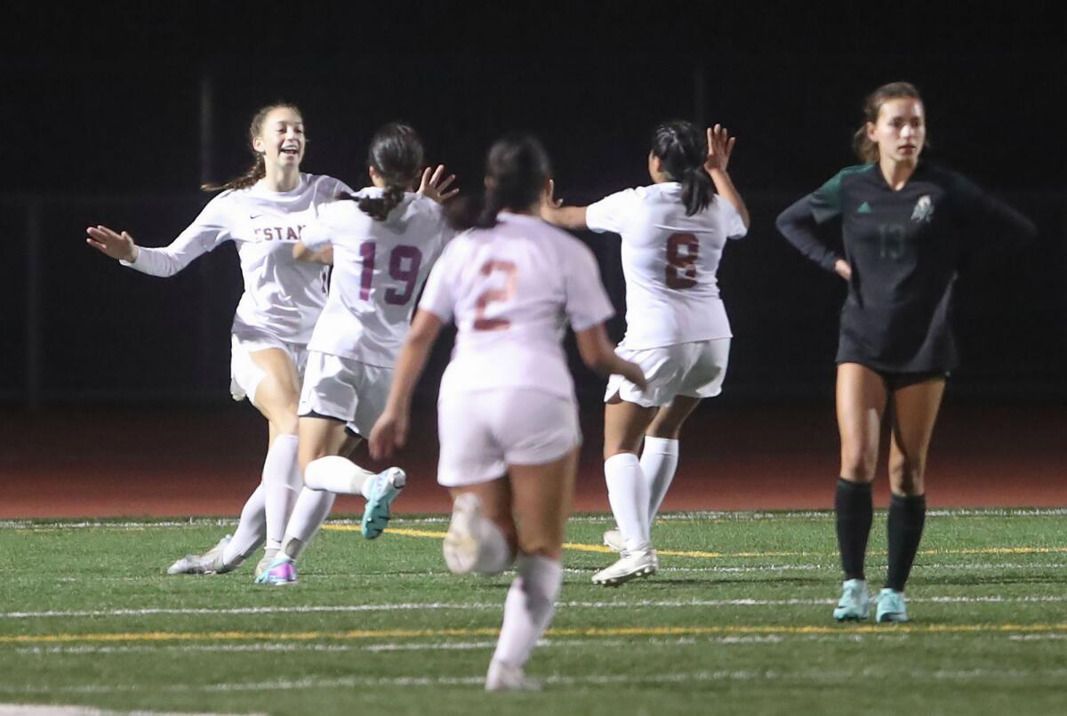 Estancia's Jana Akins (4), far left, is mobbed after scoring a goal during the Battle for the Bell girls' soccer match