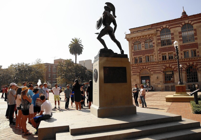 Visitors gather around the Tommy Trojan statue at USC.