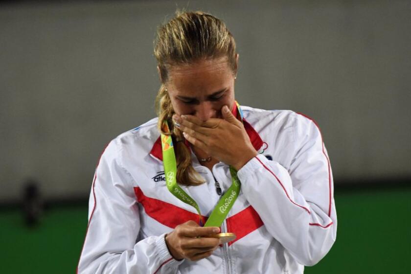 Monica Puig of Puerto Rico gets emotional while holding her gold medal for women's tennis during the podium ceremony on Aug. 13.