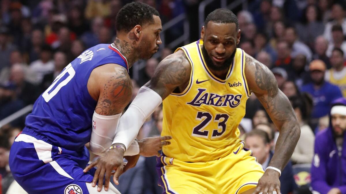Lakers' LeBron James spins to the basket against Clippers' Mike Scott in the second quarter.
