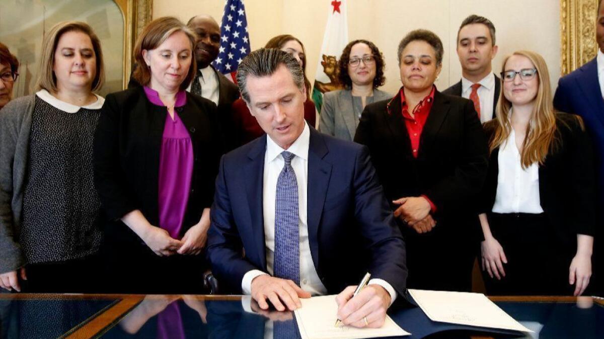 Gov. Gavin Newsom signs an executive order placing a moratorium on the death penalty in California on Wednesday.