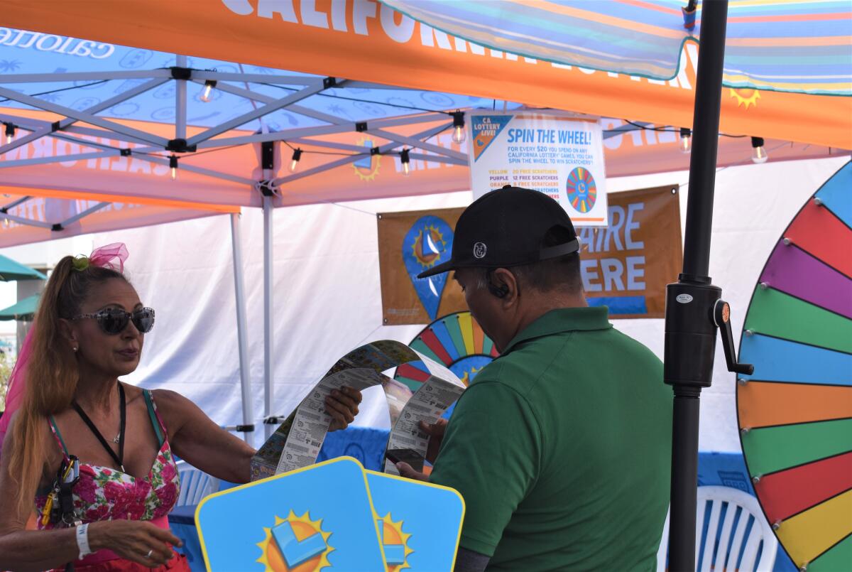 A visitor buys scratch-off tickets Thursday at an OC Fair California lottery booth, where one fairgoer won $1 million.