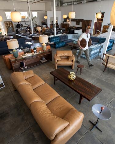 A pair of leather lounge chairs with lamps behind them in a furniture store showroom