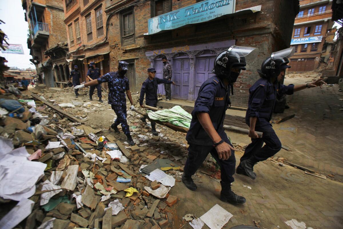 Nepalese rescue workers carry a body recovered from a collapsed building in Bhaktapur, near Katmandu.