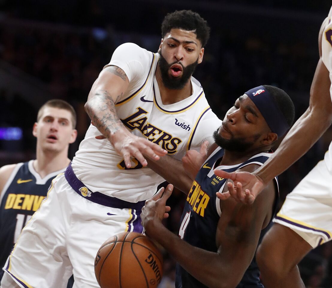 Lakers forward Anthony Davis fights for a rebound with Nuggets forward Paul Millsap.