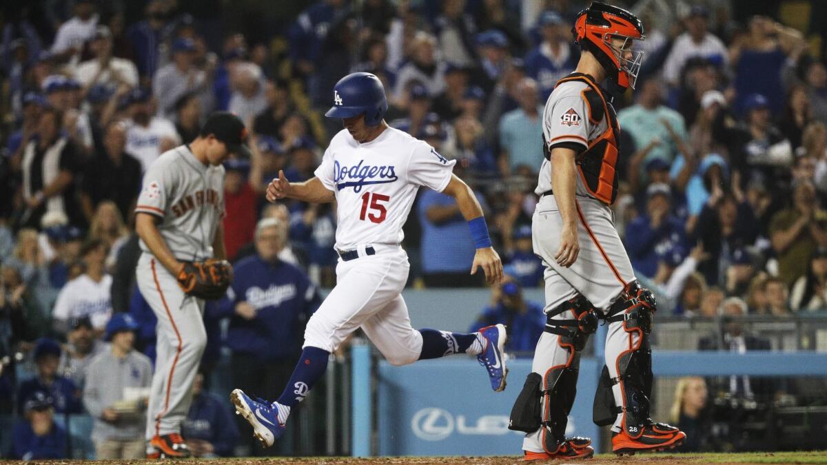 Los Angeles Dodgers catcher Austin Barnes scores on an error by San Francisco Giants left fielder Gregor Blanco in the fourth inning at Dodger Stadium.