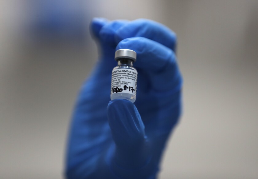 A nurse holds a vial of the Pfizer-BioNTech COVID-19 vaccine in London.