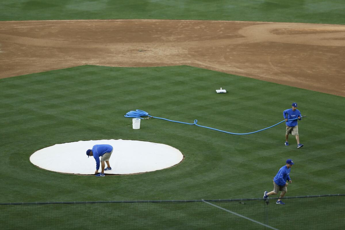 Grounds crew workers prepare the field at Dodger Stadium before a baseball game against the San Francisco Giants on May 9.