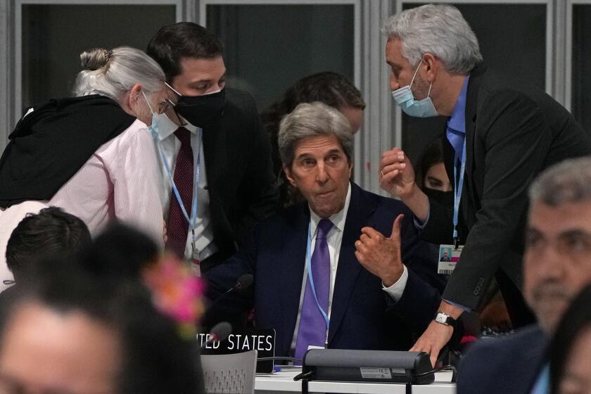 John Kerry, United States Special Presidential Envoy for Climate, center, confers during a stocktaking plenary session at the COP26 U.N. Climate Summit in Glasgow, Scotland, Saturday, Nov. 13, 2021. Going into overtime, negotiators at U.N. climate talks in Glasgow are still trying to find common ground on phasing out coal, when nations need to update their emission-cutting pledges and, especially, on money. (AP Photo/Alastair Grant)