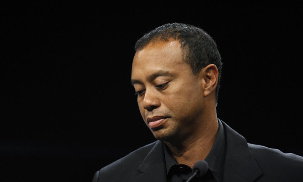 Tiger Woods looks down during a news conference in Washington on March 24. Woods will miss the Masters for the first time in his career after having surgery on his back.