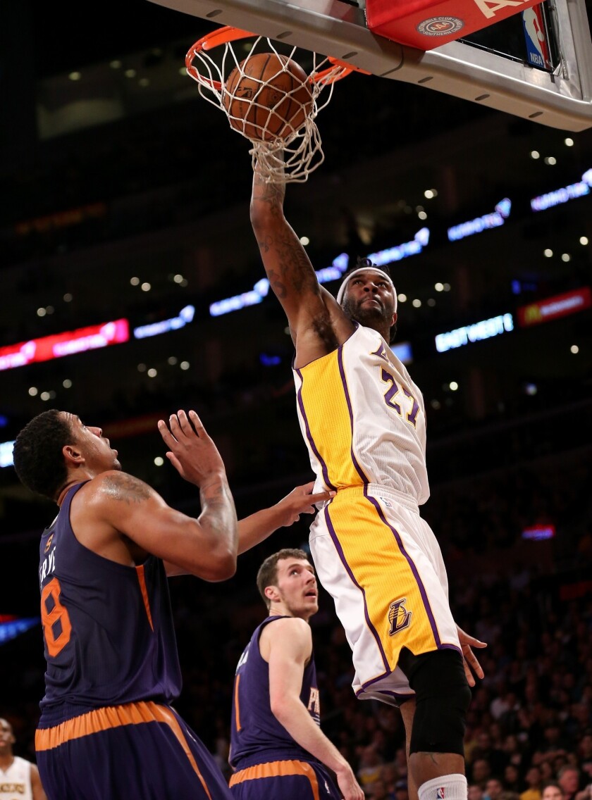 Lakers power forward Jordan Hill dunks over Phoenix Suns forward Channing Frye during the first half of their game at Staples Center.