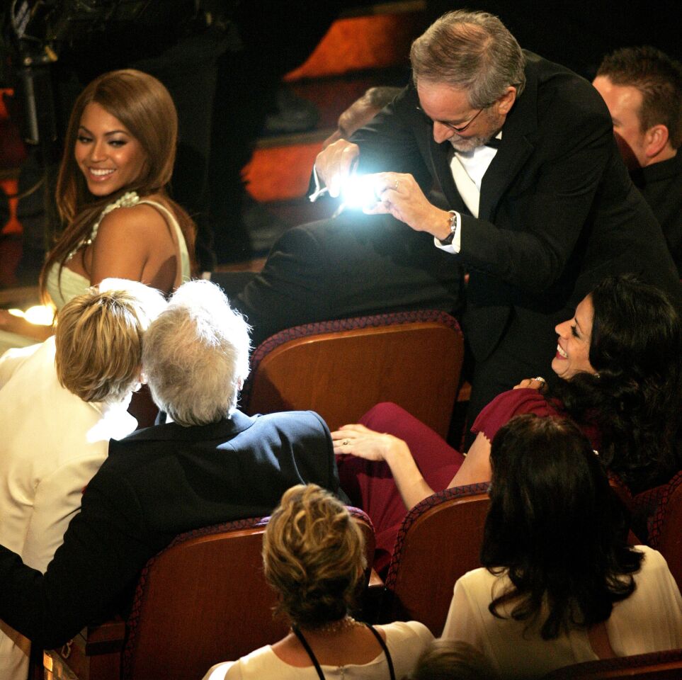 Steven Spielberg snaps a photo of Ellen DeGeneres and Clint Eastwood while Beyoncé looks on during the 79th Academy Awards.