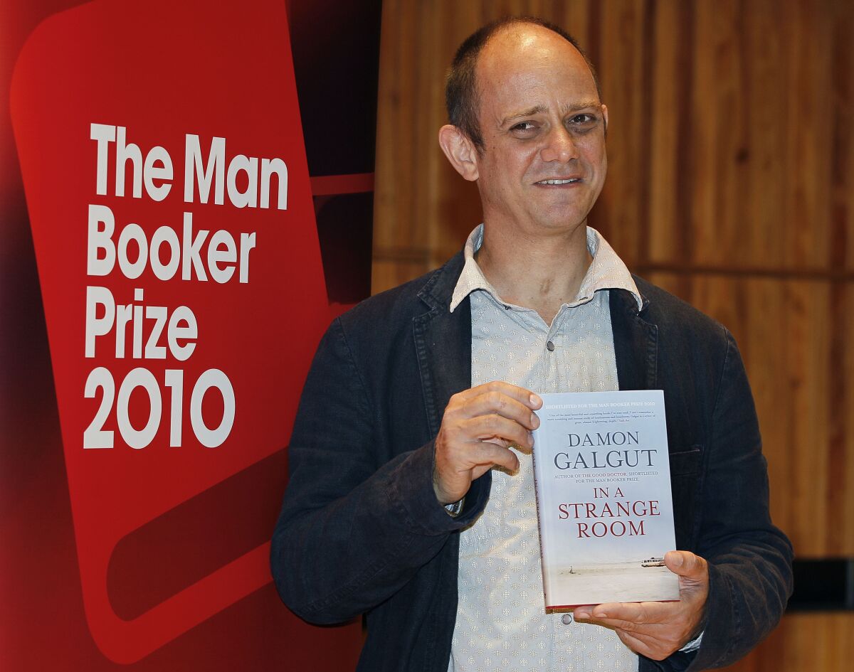 FILE - Damon Galgut with his book 'In a Strange Room' takes part in a photocall on the stage of the Royal Festival Hal in London, Oct. 10, 2010. Novels by Damon Galgut and Colm Toibin are among eight books contending for Britain’s Rathbones Folio Prize for literature. Galgut’s Booker Prize-winning South African story “The Promise” and Toibin’s novel about Thomas Mann, “The Magician,” are on the shortlist announced Wednesday, Feb. 9, 2022 for the 30,000 pound ($41,000) prize, open to both fiction and nonfiction. (AP Photo/Kirsty Wigglesworth, file)