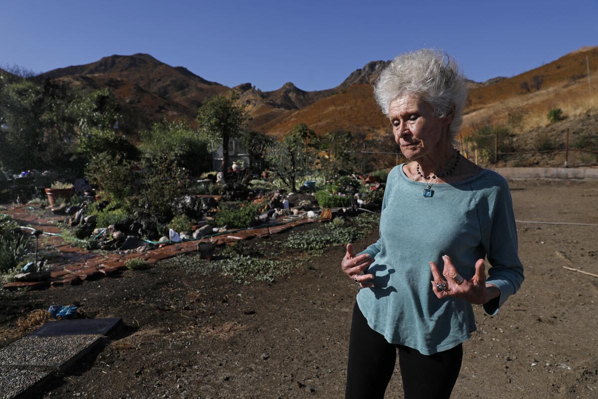 Marsha Maus, 75, stands near the garden at her burned-out lot at Seminole Springs Mobile Home Park in Agoura Hills.