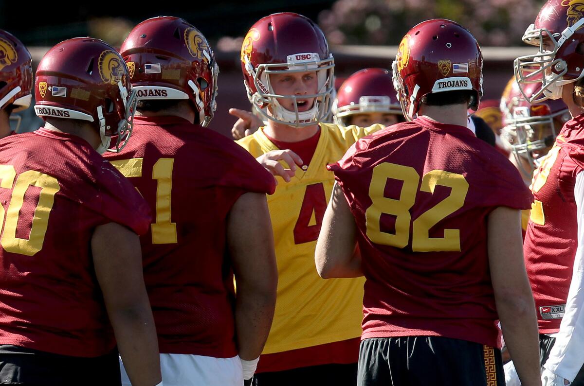Quarterback Max Browne (4) huddles up with teammates on the first day of spring practice at USC's Howard Jones Field.