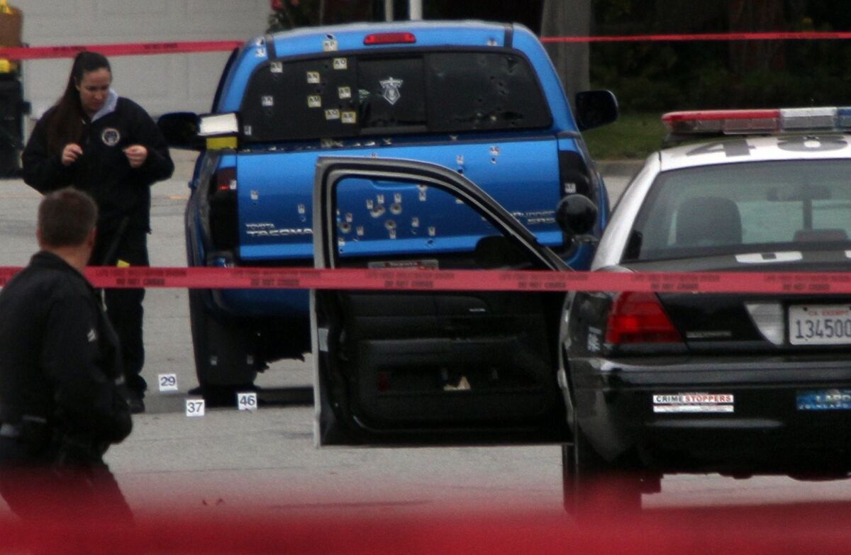 Investigators collect evidence on Feb. 7, 2013, after police officers opened fire on a pickup truck in a case of mistaken identity, wounding two women who were delivering newspapers.