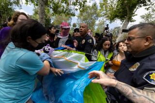 Los Angeles, CA - April 24: Campus safety officers try to confiscate tents from pro-Palestinian demonstrators at USC on Wednesday, April 24, 2024 in Los Angeles, CA. (Brian van der Brug / Los Angeles Times)