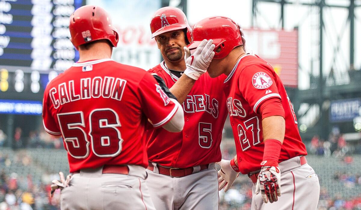 Angels' Albert Pujols (5) celebrates a three-run first inning home run with Kole Calhoun (56) and Mike Trout (27) during an Angels' 10-2 rout over the Colorado Rockies on Tuesday.
