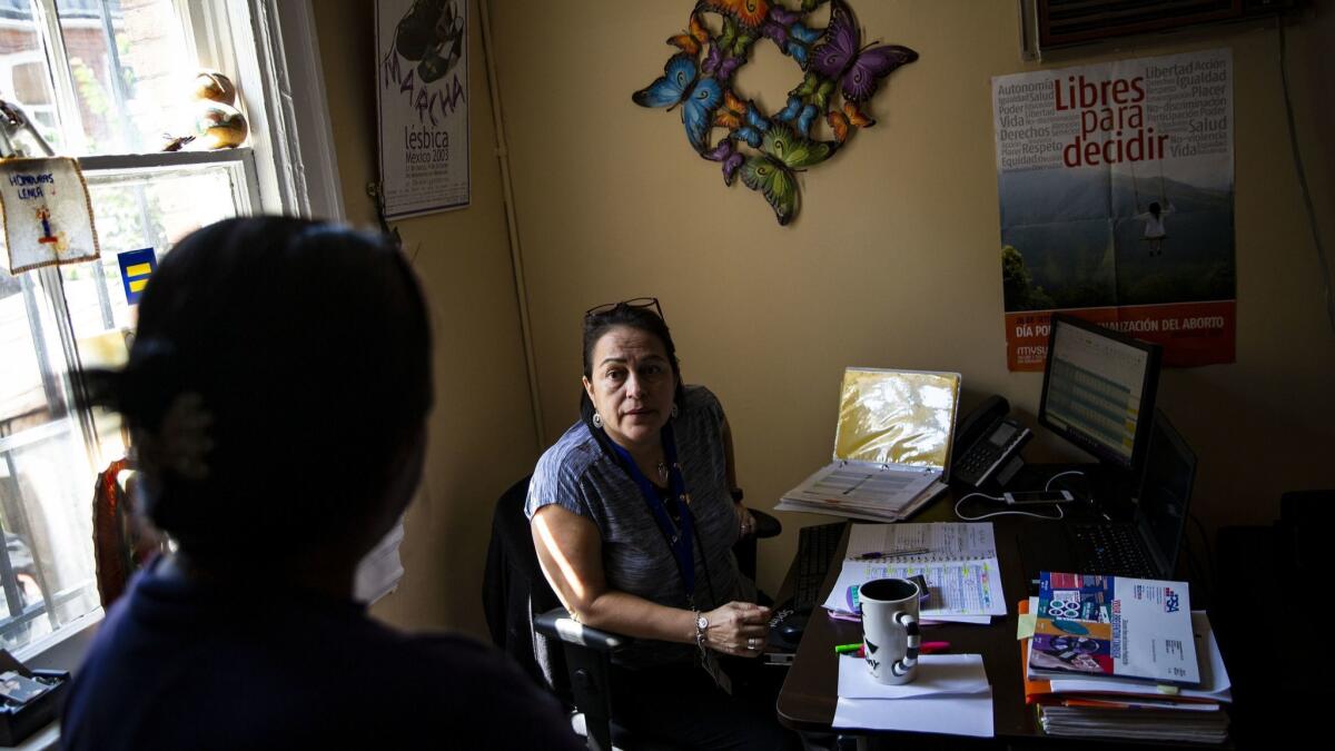 Dilcia Molina, a gender and health program manager, right, speaks with Candelaria at La Clinica Del Pueblo in Washington DC.