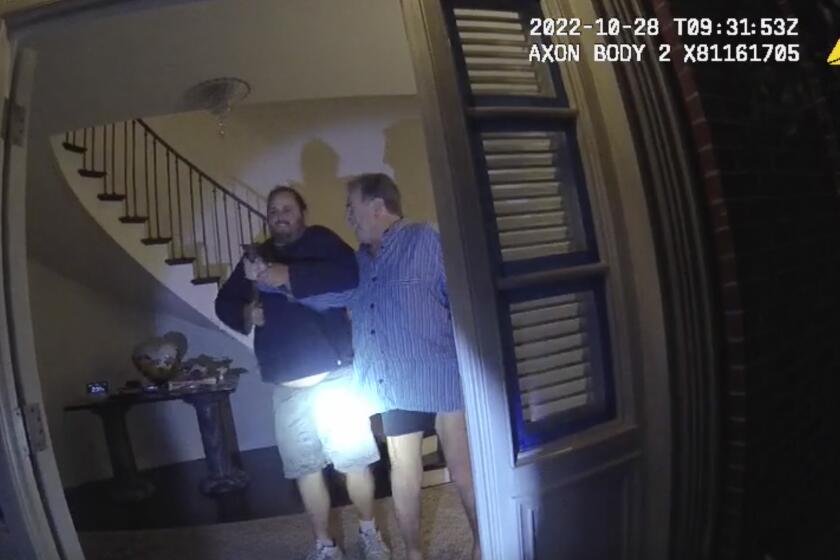 FILE - In this image taken from San Francisco Police Department body-camera video, the husband of former U.S. House Speaker Nancy Pelosi, Paul Pelosi, right, fights for control of a hammer with his assailant David DePape during a brutal attack in the couple's San Francisco home, Oct. 28, 2022. A judge has dismissed several criminal charges against Paul Pelosi's attacker, DePape, in state court. The judge ruled on Thursday, June 6, 2024, following the defense’s argument of double jeopardy. (San Francisco Police Department via AP, File)