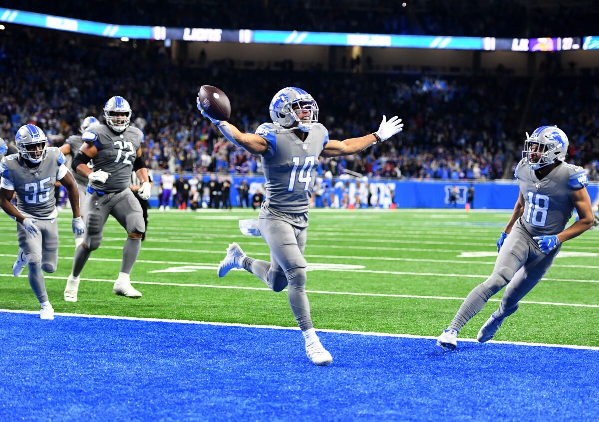 Amon-Ra St. Brown (14) of the Detroit Lions celebrates after catching a touchdown as time expired Sunday.