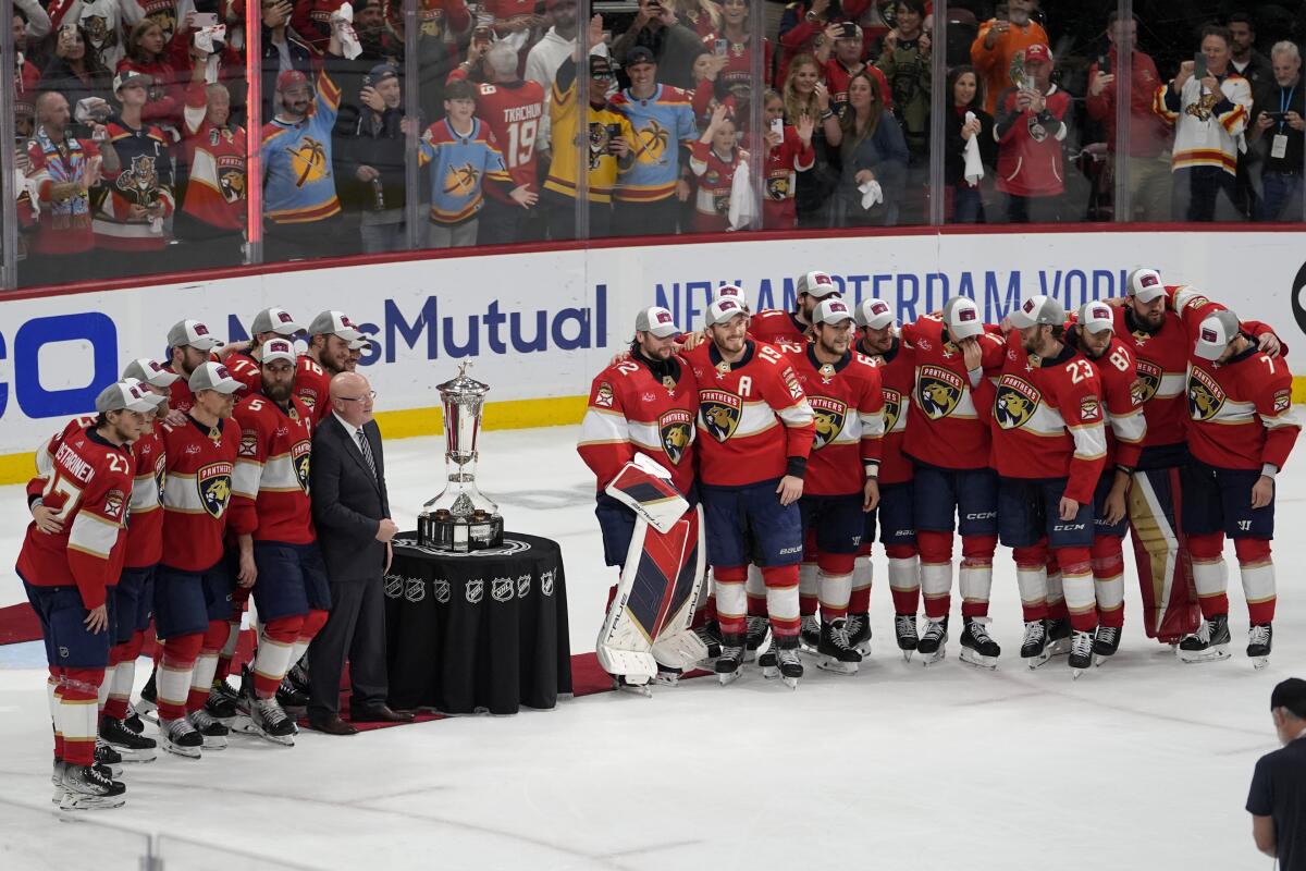 Florida Panthers players pose next to the Prince of Wales Trophy.