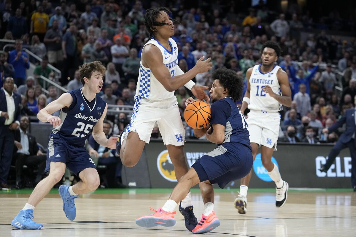 Saint Peter's guard Matthew Lee, right, steals the all from Kentucky guard TyTy Washington Jr. (3) during overtime in a college basketball game in the first round of the NCAA tournament, Thursday, March 17, 2022, in Indianapolis. (AP Photo/Darron Cummings)