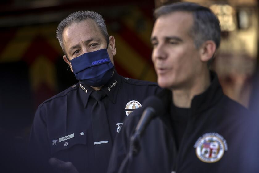 Los Angeles, CA - January 06: LAPD Chief Moore, left, watches as Mayor Eric Garcetti addresses a press conference held at Los Angeles Fire Station 3 on Thursday, Jan. 6, 2022 in Los Angeles, CA. (Irfan Khan / Los Angeles Times)