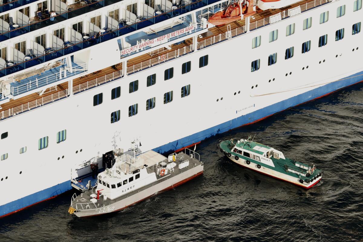 A Japanese Coast Guard patrol boat, left, is brought alongside the Diamond Princess last week to take passengers who test positive for coronavirus to hospitals near Tokyo.