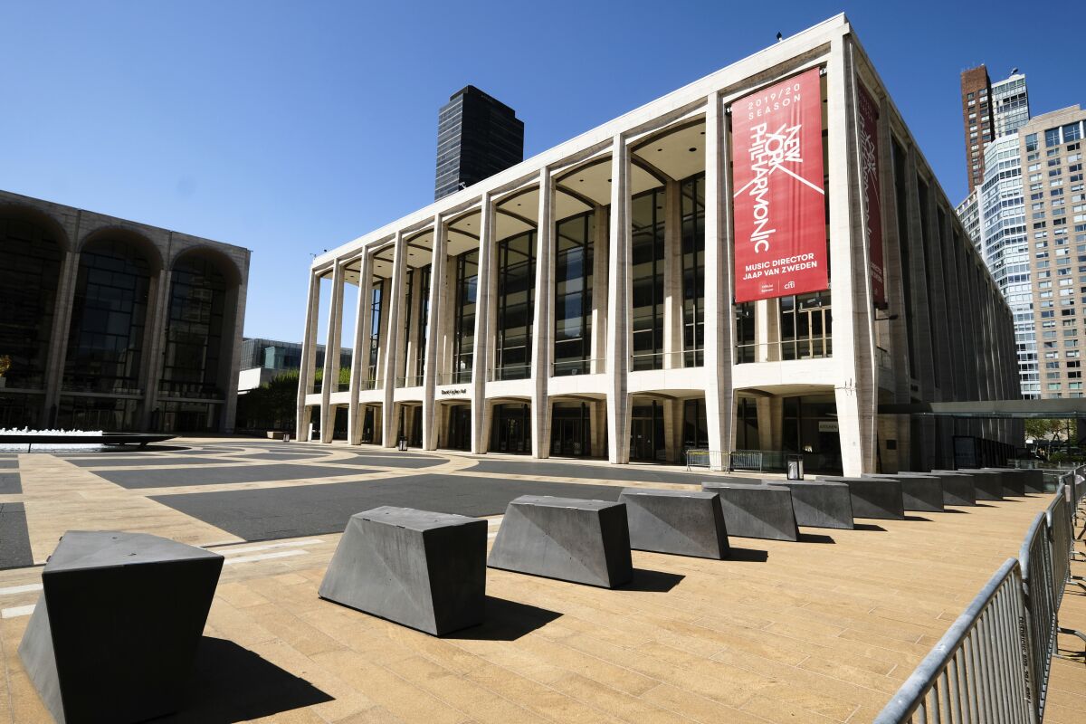 FILE - This May 12, 2020 file photo shows David Geffen Hall at Lincoln Center, closed during COVID-19 lockdown, in New York. The New York Philharmonic, silenced from performances at Lincoln Center since March by the novel coronavirus pandemic, has agreed to a four-year labor contract with its musicians through Sept. 20, 2024, that retains wage cuts throughout the entire deal. (Photo by Evan Agostini/Invision/AP, File)