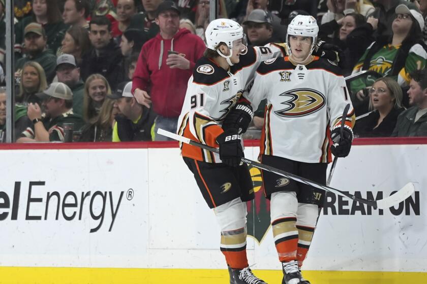 Anaheim Ducks right wing Troy Terry, right, celebrates with center Leo Carlsson.