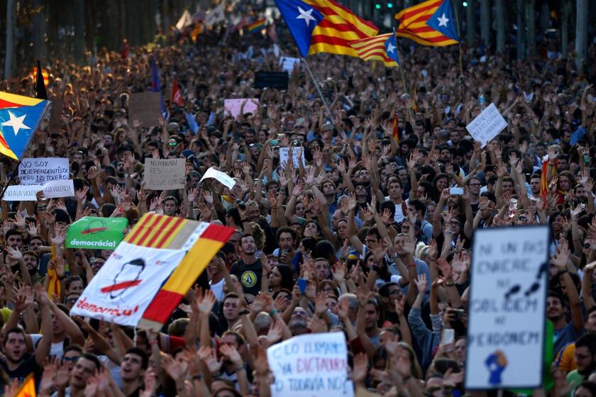 Demonstrators shake their hands as a sign of peaceful protest as they march in downtown Barcelona, Spain, Tuesday Oct. 3, 2017. Thousands of people demonstrated against the confiscation of ballot boxes and charges on unarmed civilians during Sunday's referendum, declared illegal by Spain's Constitutional Court, on Catalonia's secession from Spain.(AP Photo/Francisco Seco)