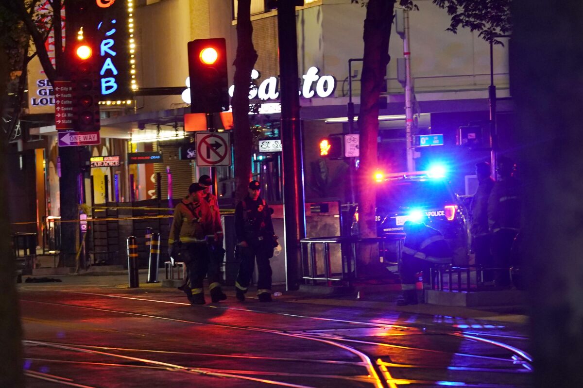 Emergency personnel walk along a city street at night