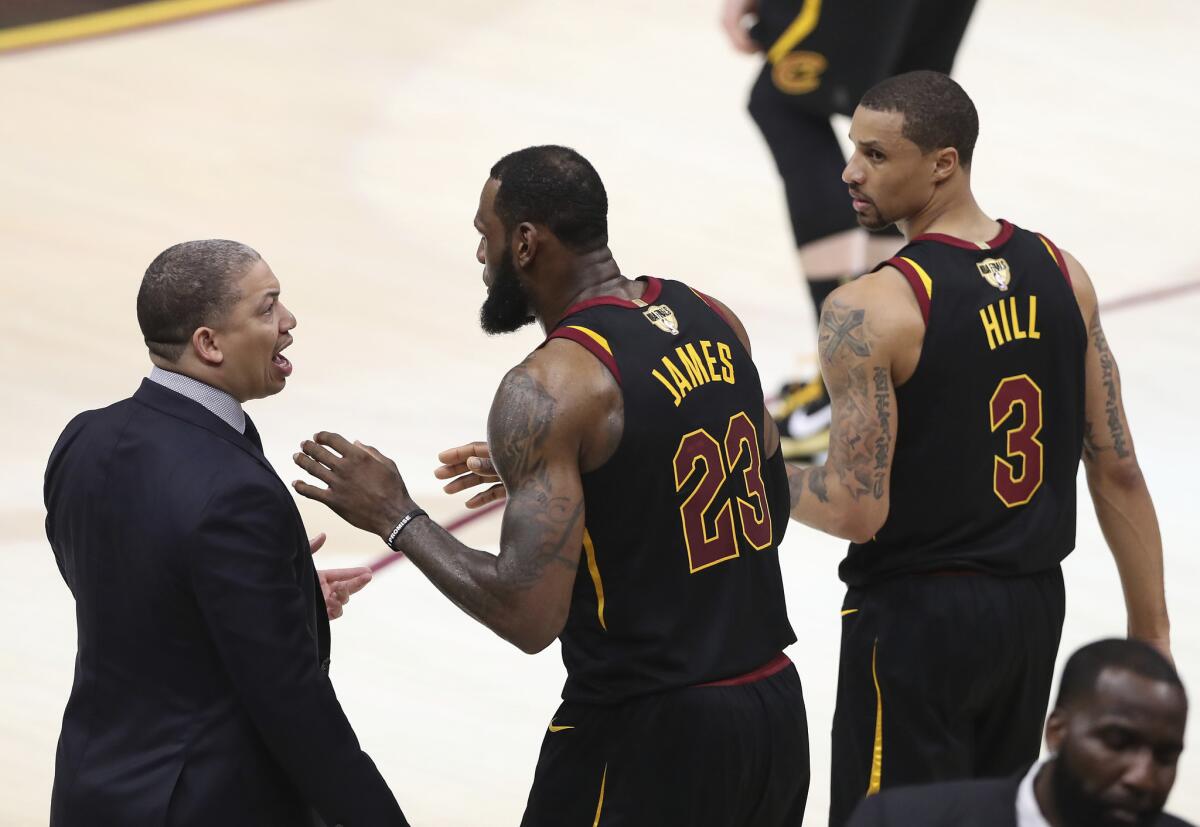 Tyronn Lue platica con LeBron James durante un partido cuando dirigía a los Cavaliers.