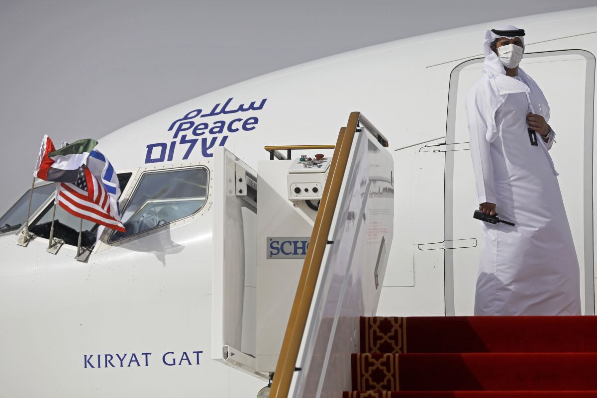 An official stands at the door of an Israeli El Al airliner after it landed in Abu Dhabi, United Arab Emirates, Monday, Aug. 31, 2020. The Star of David-adorned El Al plane landed in Abu Dhabi after flying in from Israel, carrying a high-ranking American and Israeli delegation to Abu Dhabi in the first-ever direct commercial passenger flight to the United Arab Emirates. The Israeli flag carrier’s flight Monday marks the implementation of the historic U.S.-brokered deal to normalize relations between the two nations. (Nir Elias/Pool Photo via AP)