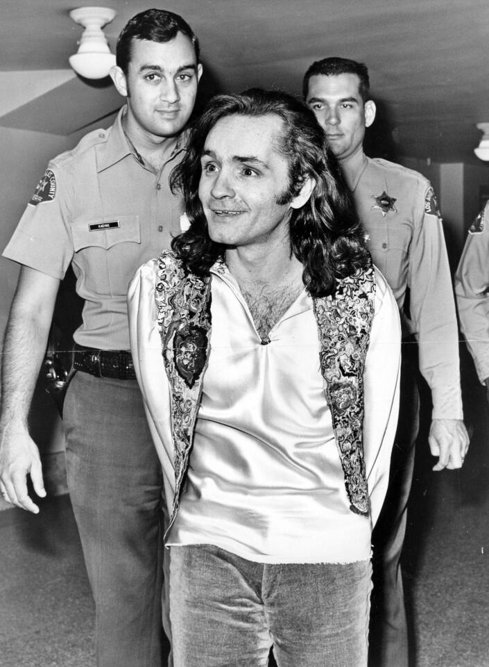 Undated staff file photo of Charles Manson handcuffed and being escorted to court.