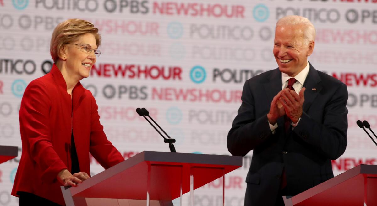 Former Vice President Joe Biden applauds for Sen. Elizabeth Warren.