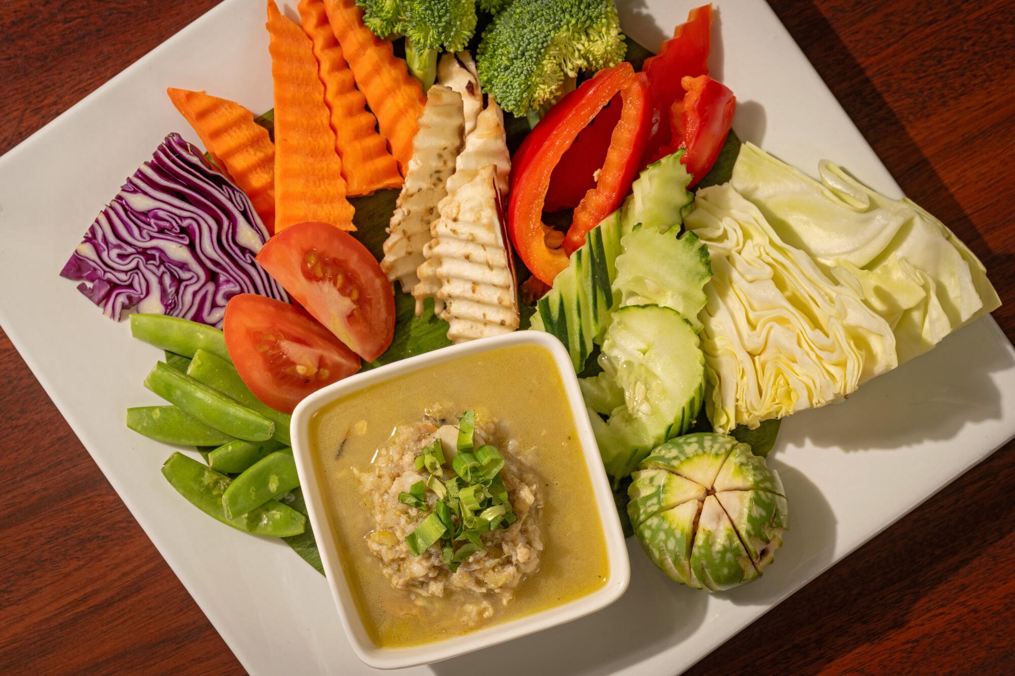 A small dish of sauce served with crinkle-cut raw vegetables.