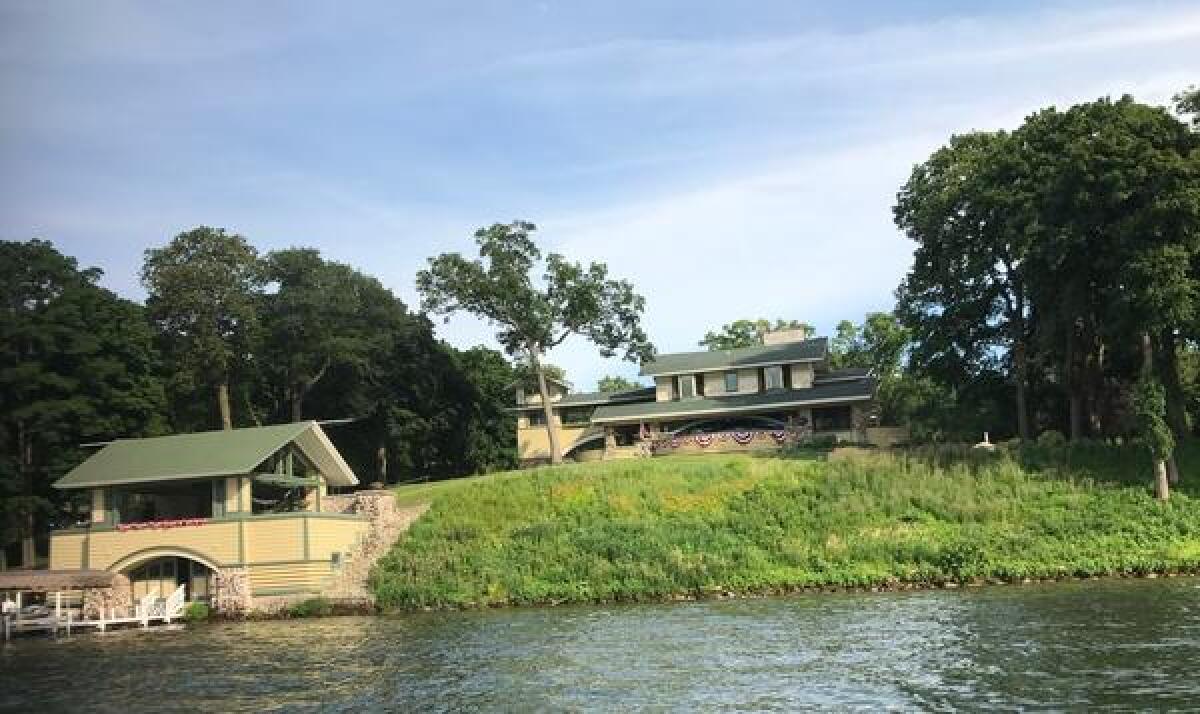 A view of the Penwern estate from Delavan Lake in Wisconsin. The rebuilt boathouse, left, was designed by architect Frank Lloyd Wright to sit below the sightline of the home's patio so that it doesn't obstruct views of the lake. The 1902 house is owned by Sue and John Major of Rancho Santa Fe.