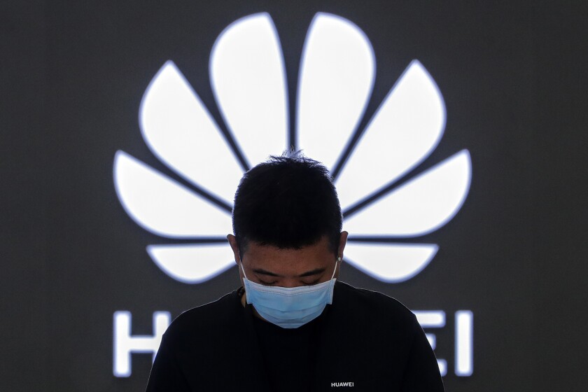 FILE - In this Aug. 31, 2020, file photo, an employee wearing a face mask to help curb the spread of the coronavirus stands inside a Huawei flagship store in Beijing. Chinese telecommunications equipment firm Huawei said Monday, April 12, 2021, that it has reached an agreement with HSBC in Hong Kong to obtain documents that its chief financial office Meng Wanzhou hopes will help prevent her extradition to the U.S.(AP Photo/Andy Wong, File)