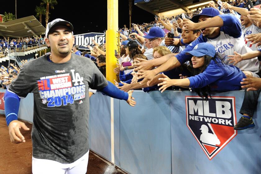 Dodgers first baseman Adrian Gonzalez slaps hands with fans as he runs around the outfield of Dodger Stadium on Sept. 24 while celebrating the club's National League West title.