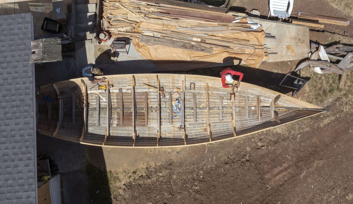 Birds-eye view of Tom Kottmeier, at right, and friend Ivar Schoenmeyr, left, working on a Viking boat replica.