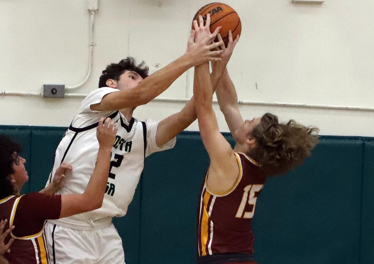 Costa Mesa'a Riley Weinstein (22) and Estancia's Jagger Steck (15) jump for the rebound in the Battle for the Bell game.